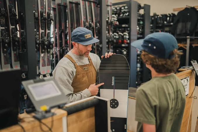 snowboard size chart | customer getting sized for rentals